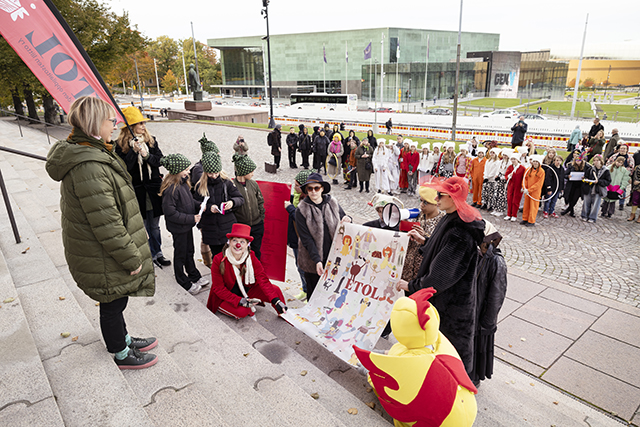 Kuvassa lapsia ja nuoria Eduskuntatalon portailla luovuttamassa julkilausumaa tulevaisuusvaliokunnan puheenjohtaja Aino-Kaisa Pe